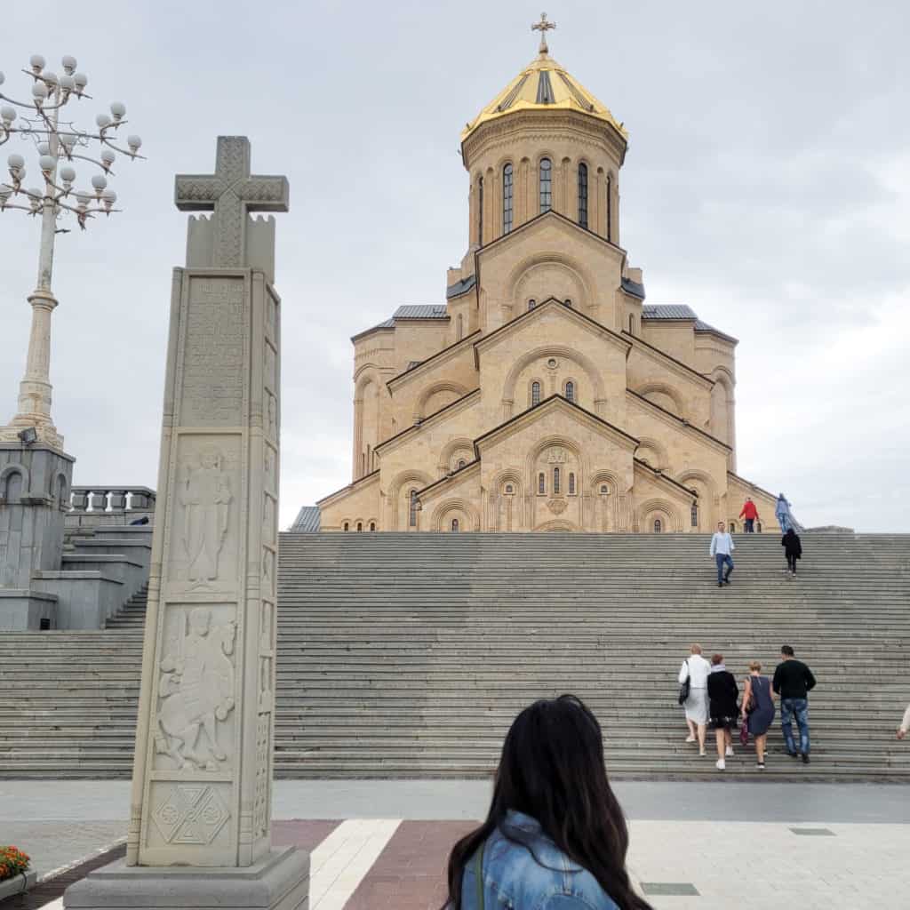 A woman looking at Sameba Cathedral in Tbilisi, Georgia