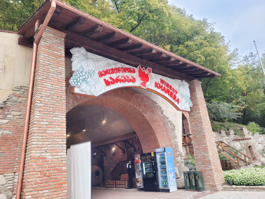 A brick entranceway with large red letter signage set in front of trees