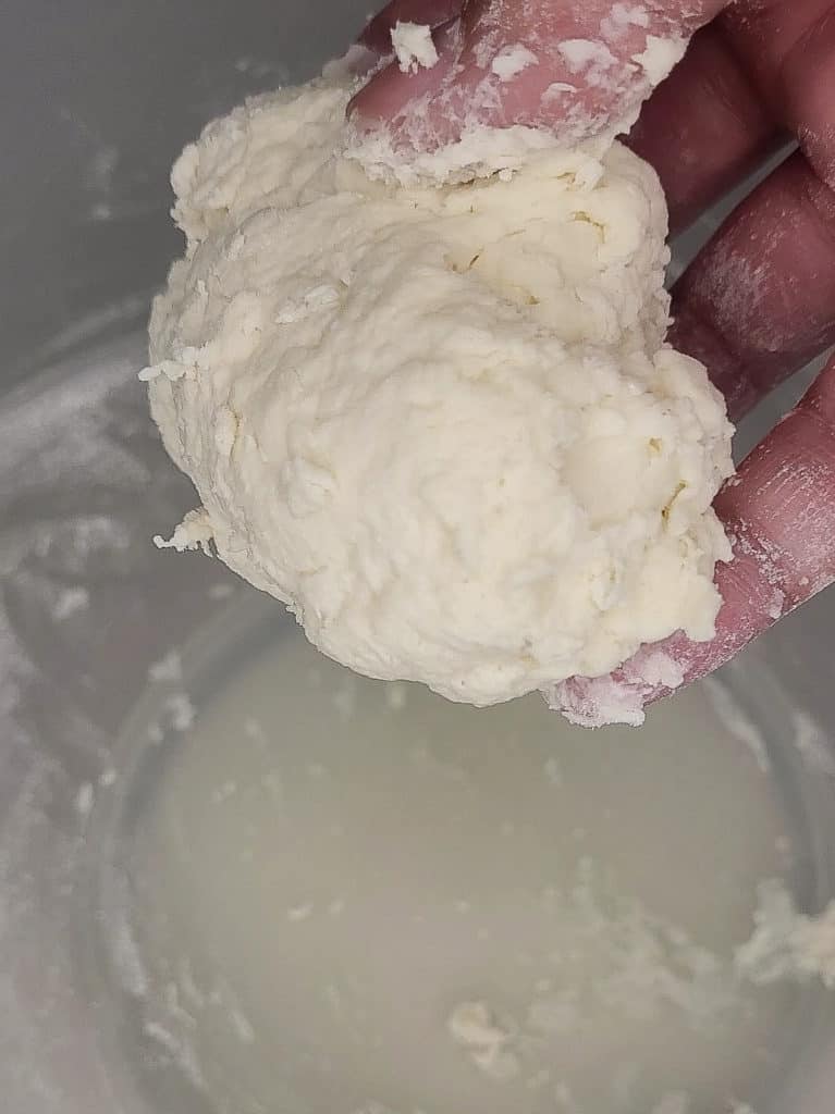 A clump of dough held by a hand
