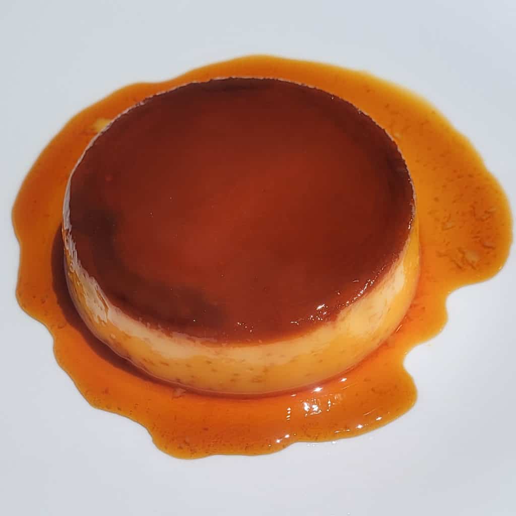 An overhead image of a Filipino style flan on a white plate