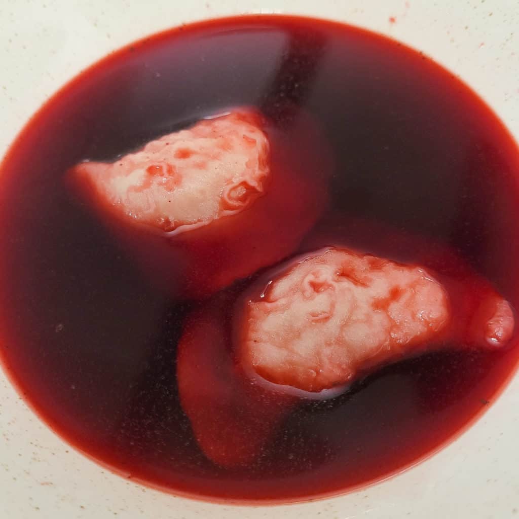 Polish red borscht with pierogi in a bowl