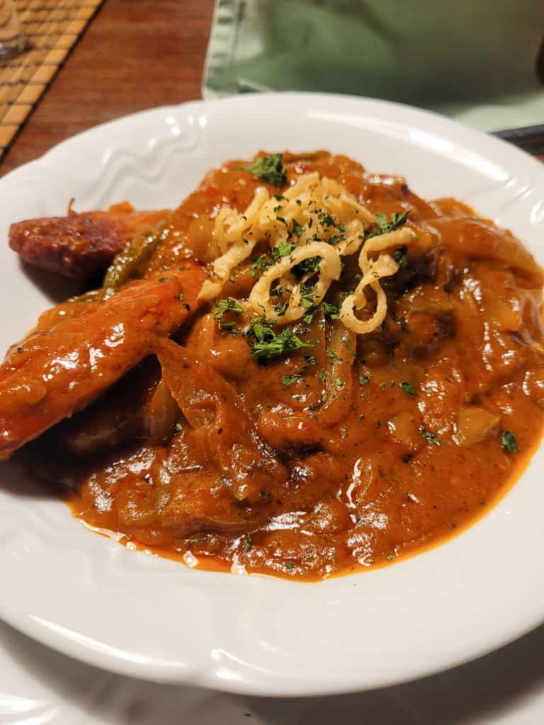 Sausages braised in a stew on a white plate