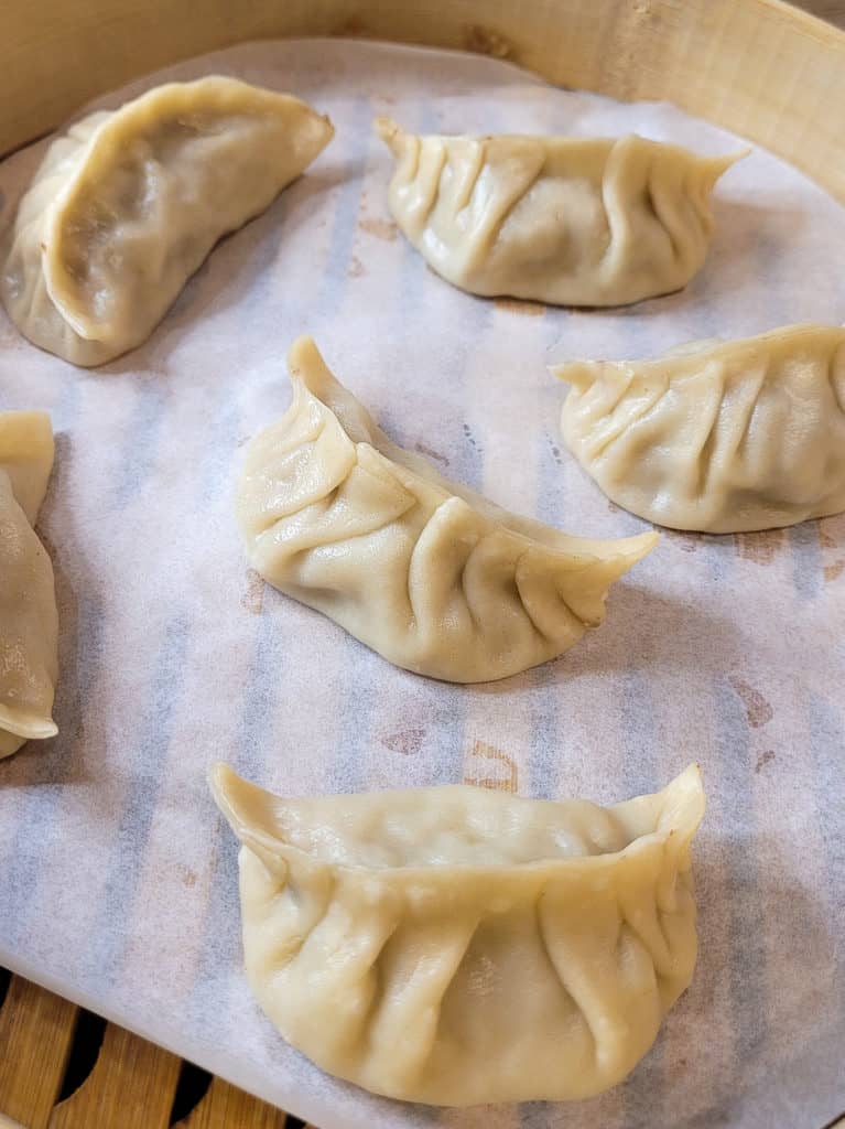 Pork and cabbage dumplings in a bamboo steamer