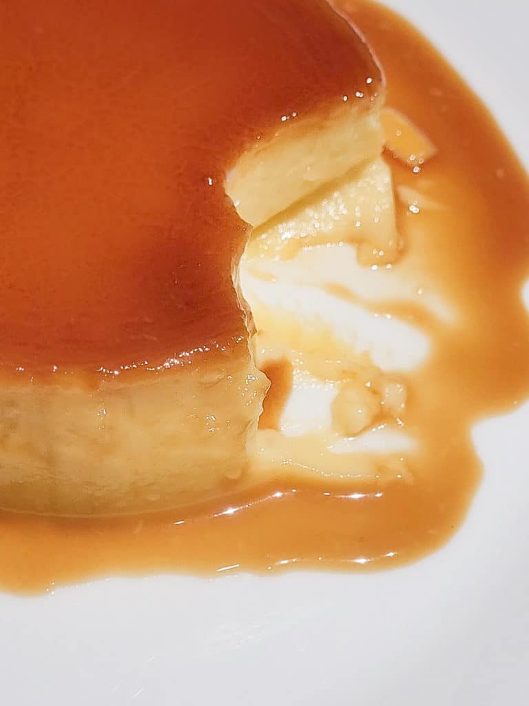 A closeup of Filipino style flan with bites taken out of it