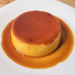A smooth Filipino style flan on a white plate