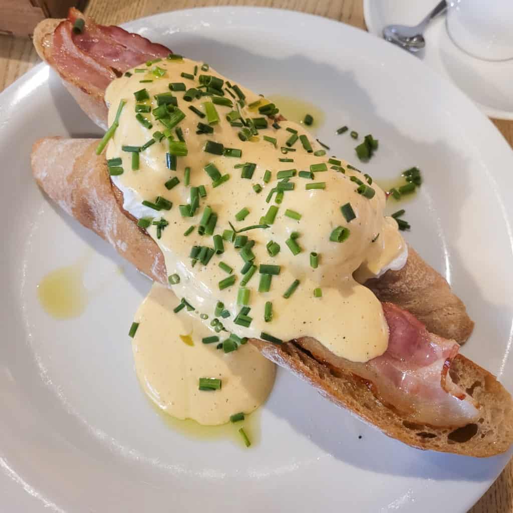 Eggs benedict on a white plate in a restaurant in Kazimierz district