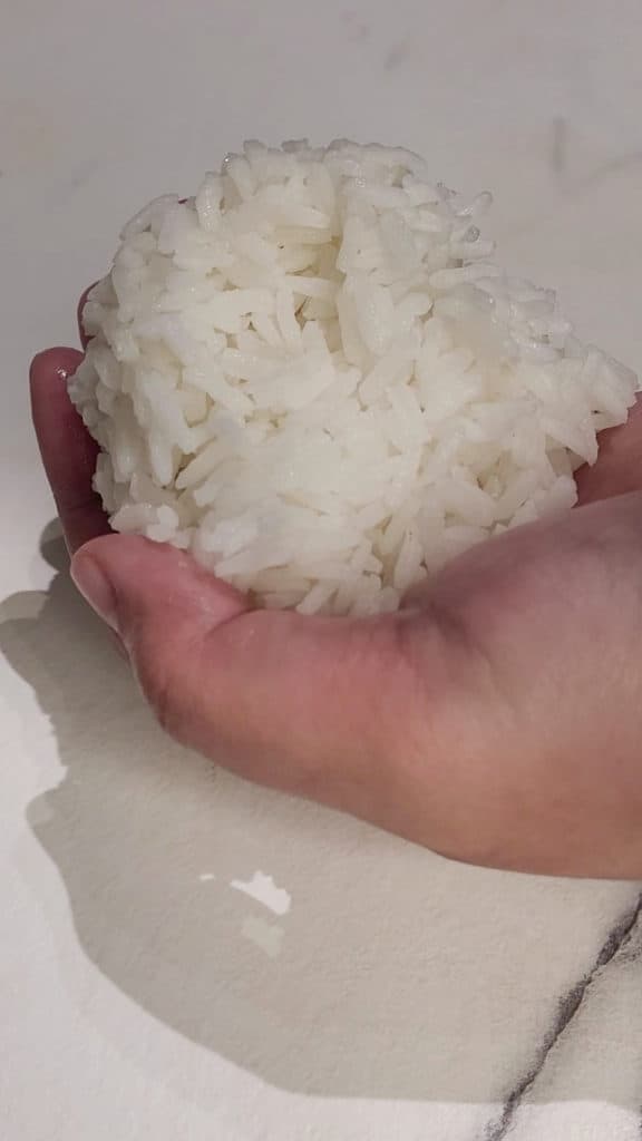 Cooked rice in the palm of a hand