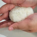 A rice ball being shaped by hands