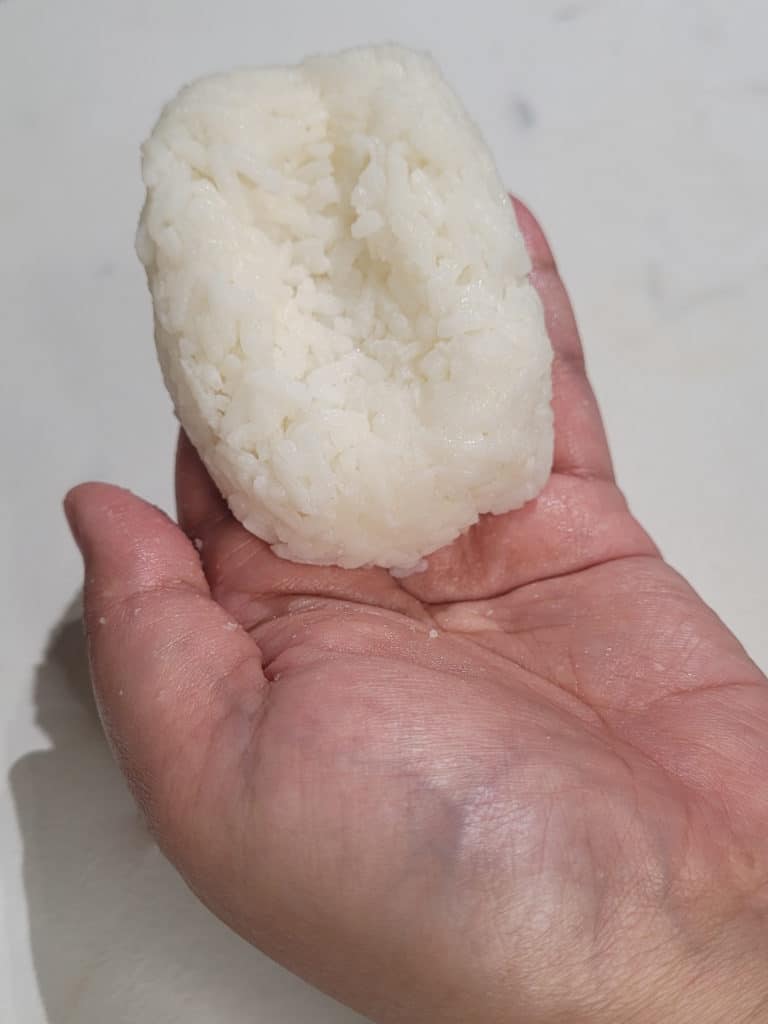 A rectangle shaped rice ball with an indent in the middle