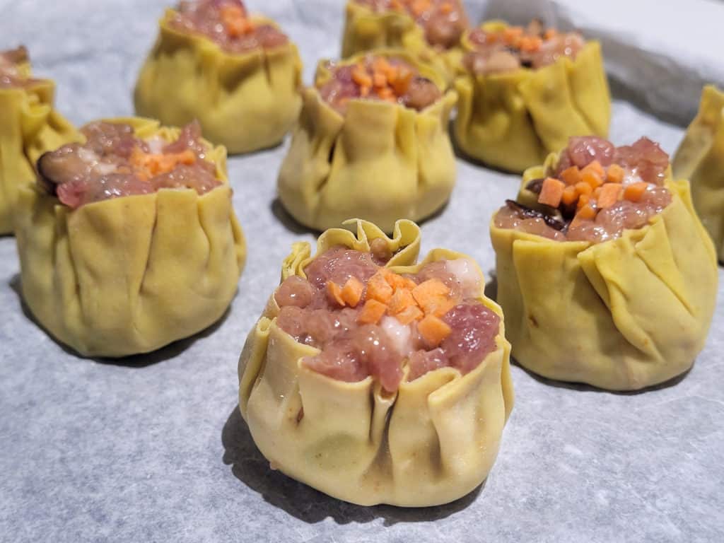 Uncooked siu mai on wax paper