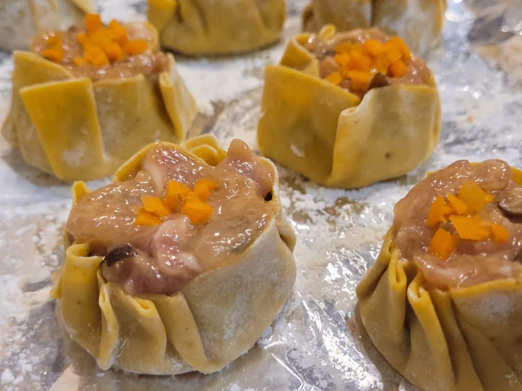 Closeup of siu mai on a foil lined pan