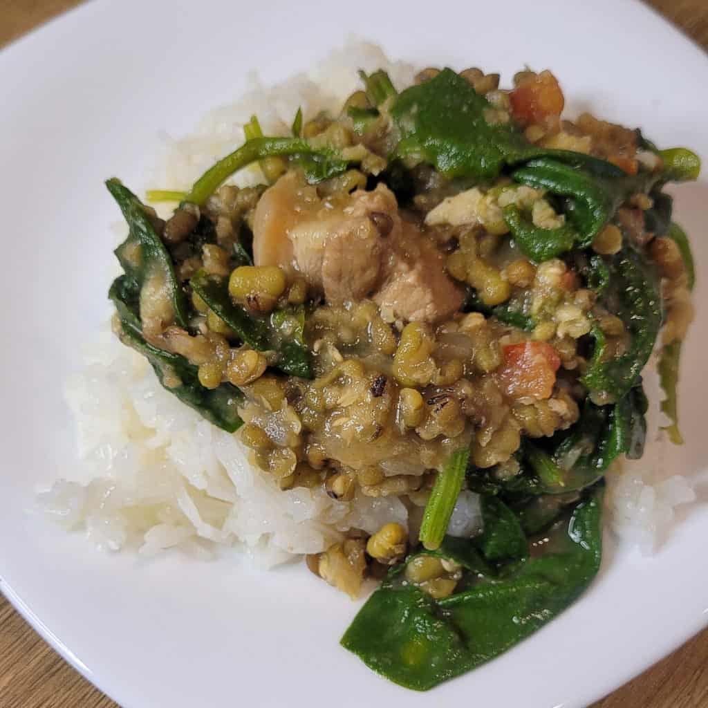 A white plate with rice and Filipino mongo on top of the rice