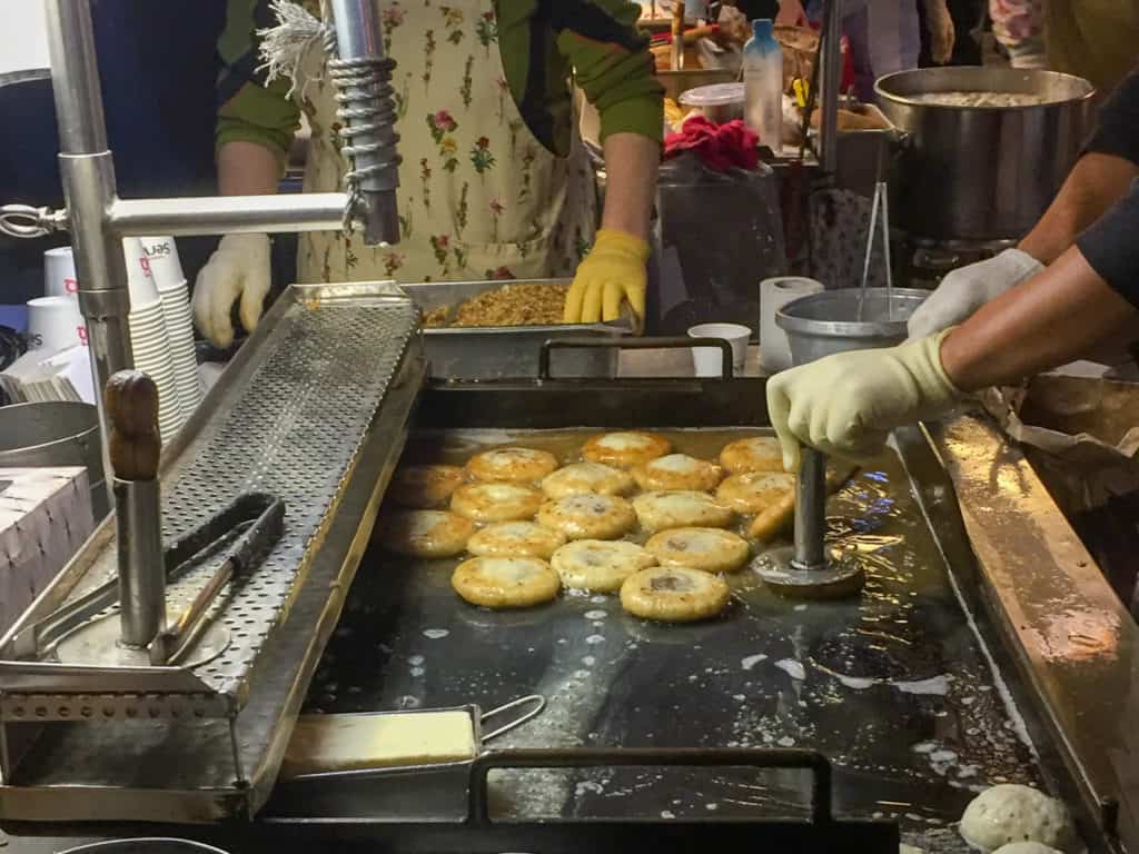 Hotteok in the making on a sheet fryer with butter