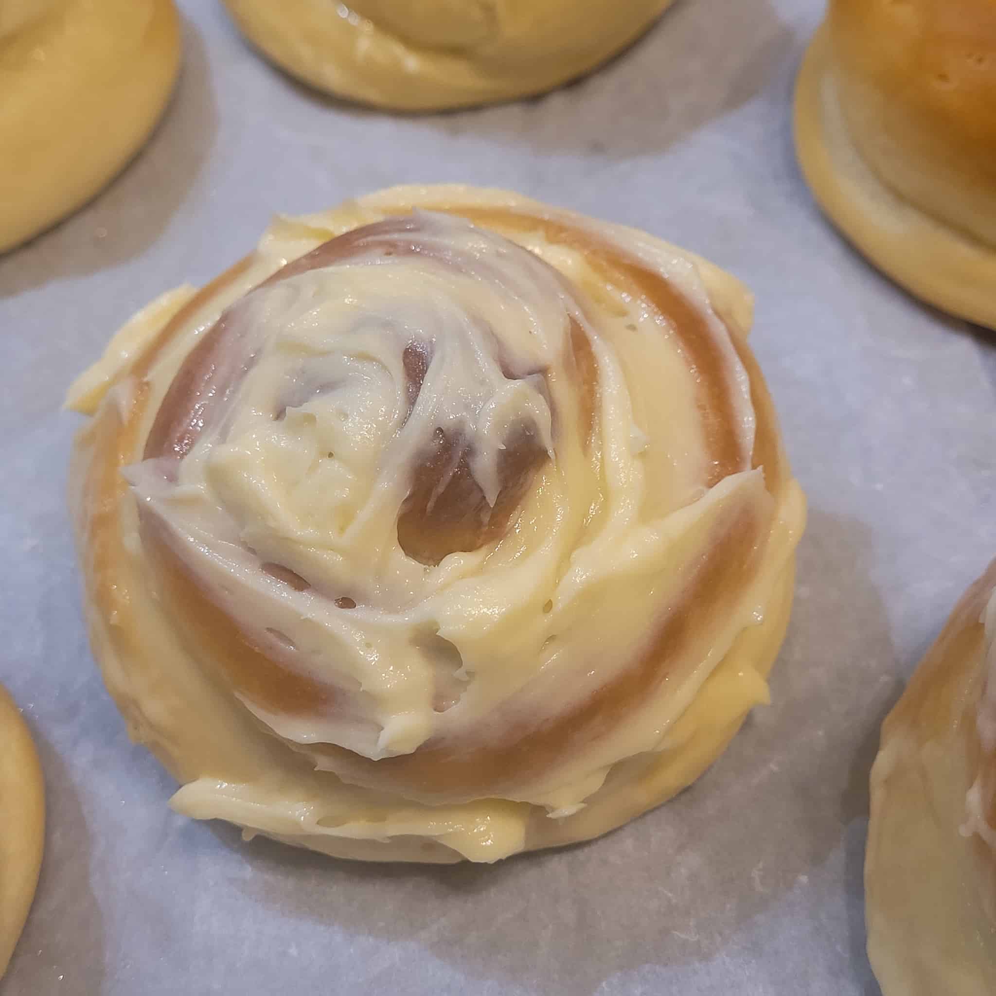 Ensaymada with buttercream topping on parchment paper