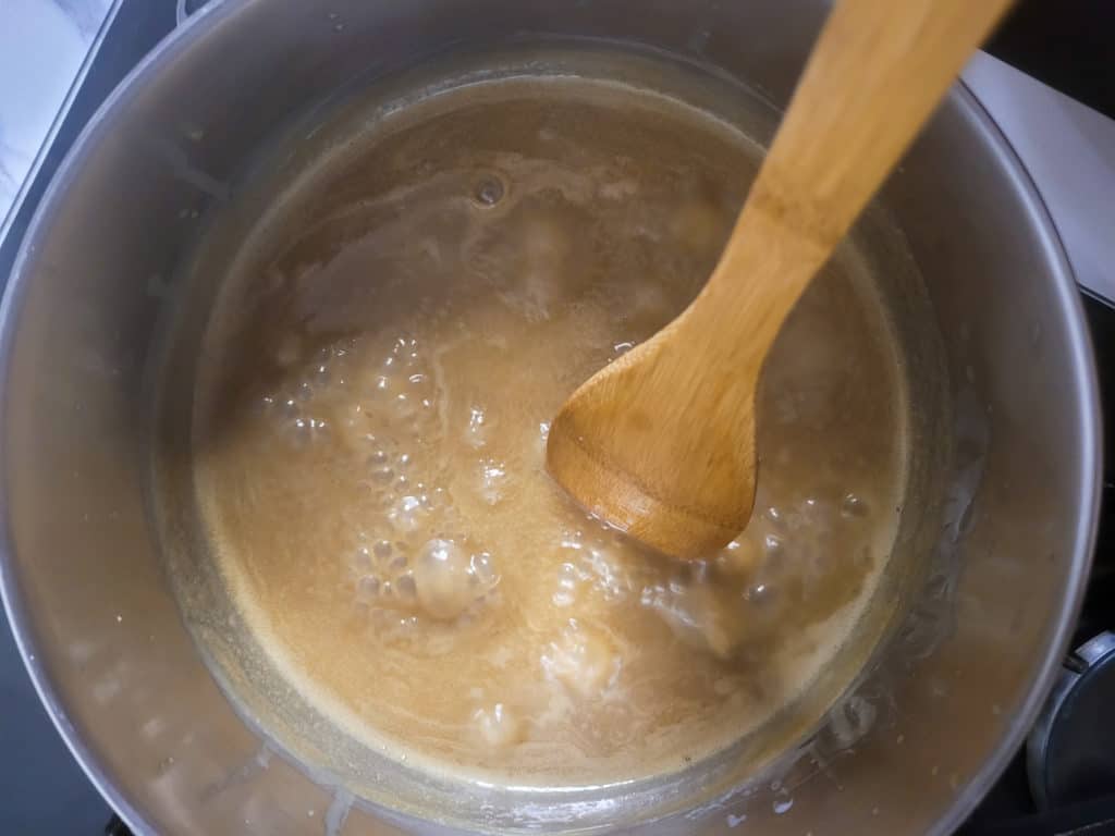 Caramel sauce boiling in a silver pot