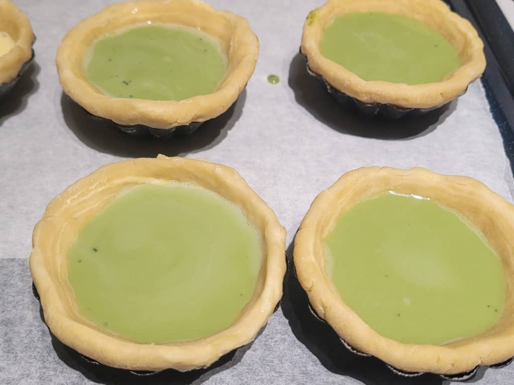Smooth surfaces on matcha Portuguese egg tarts before going in the oven