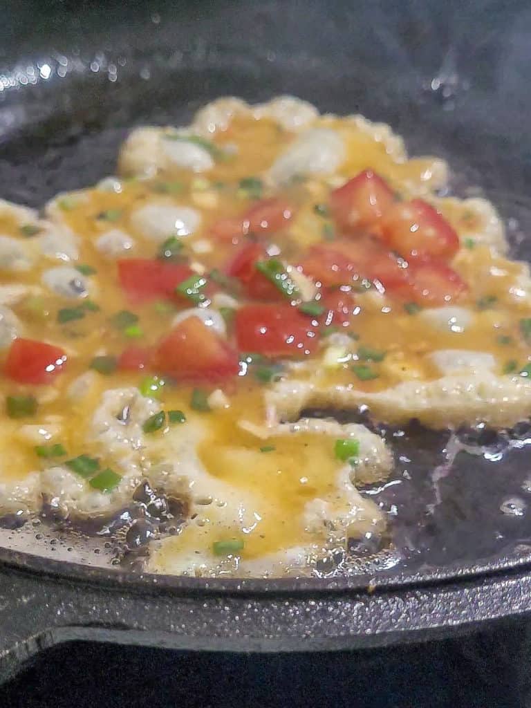 Egg and vegetables frying on a pan