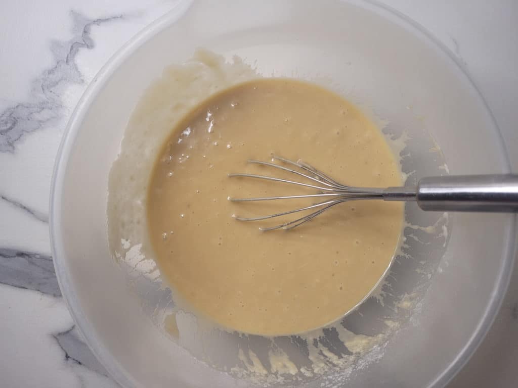 Bowl of mixed ingredients with a silver whisk