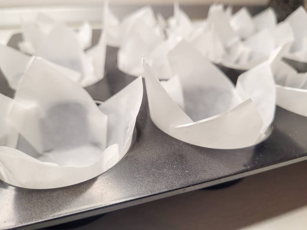 Closeup of paper shaped as muffin liners in a pan