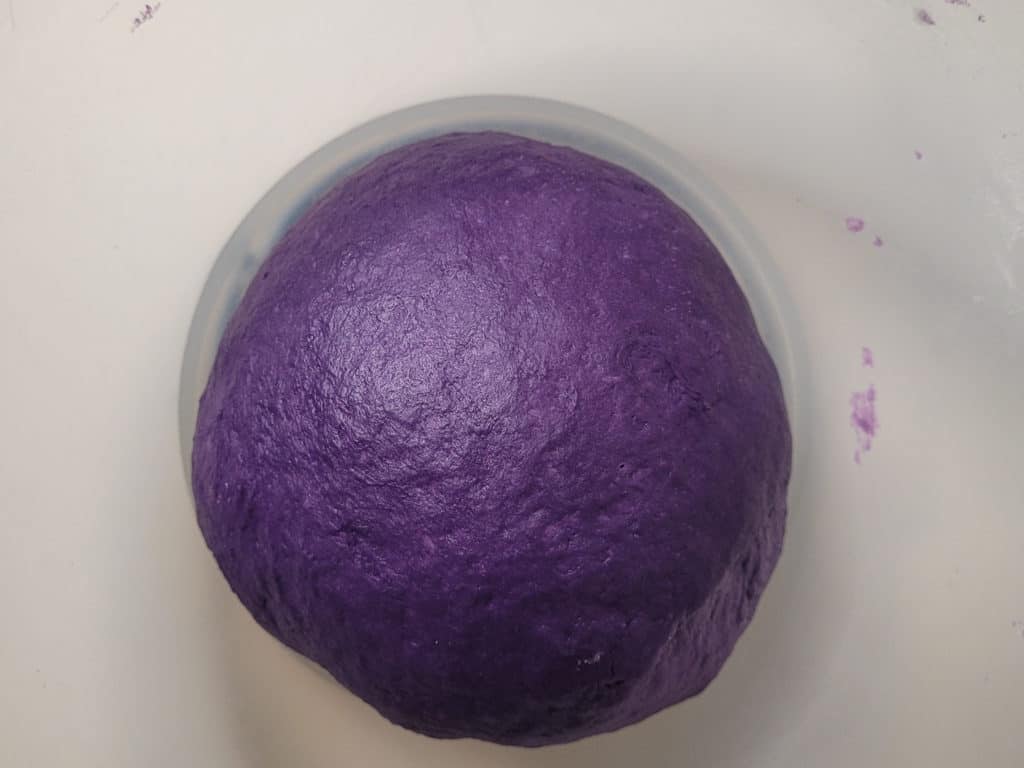 Purple dough resting in a bowl