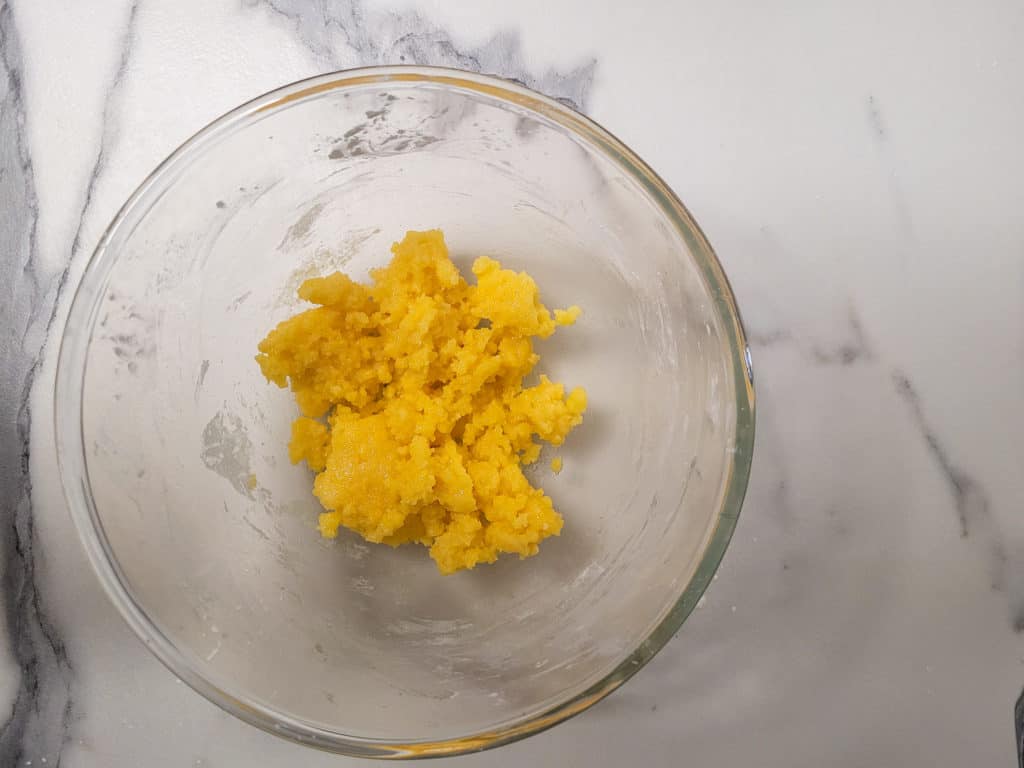 Egg yolks creamed with other ingredients in a clear bowl