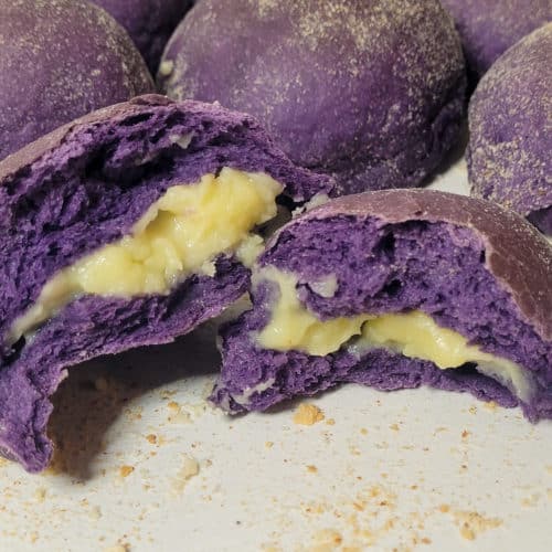 Cross section of ube pandesal in front of other buns