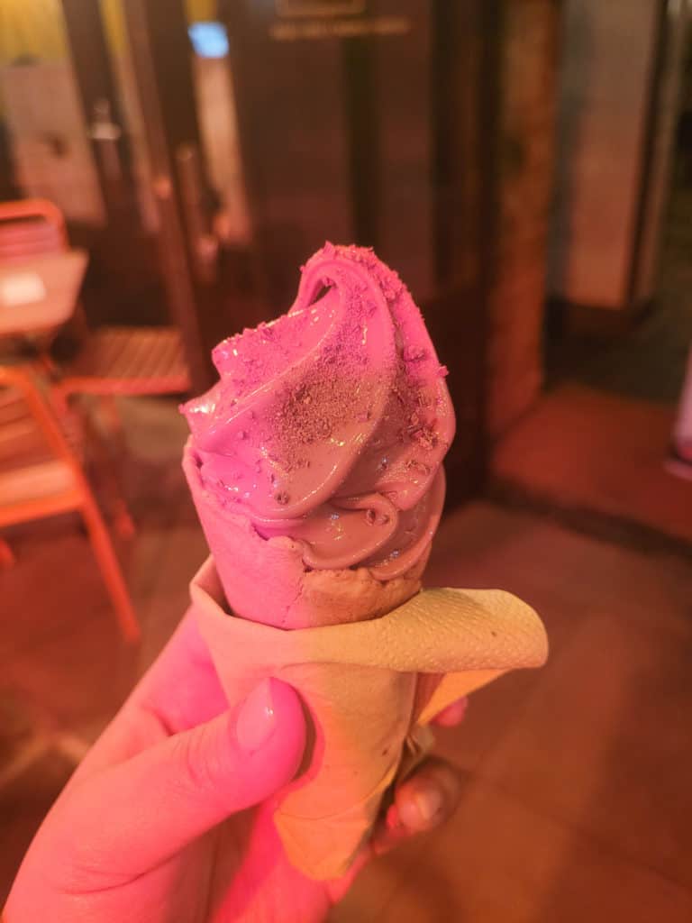 A closeup of ice cream lit against a neon sign in London