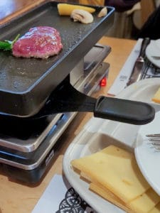 What to eat in Zurich: Melted cheese with machine next to cheese