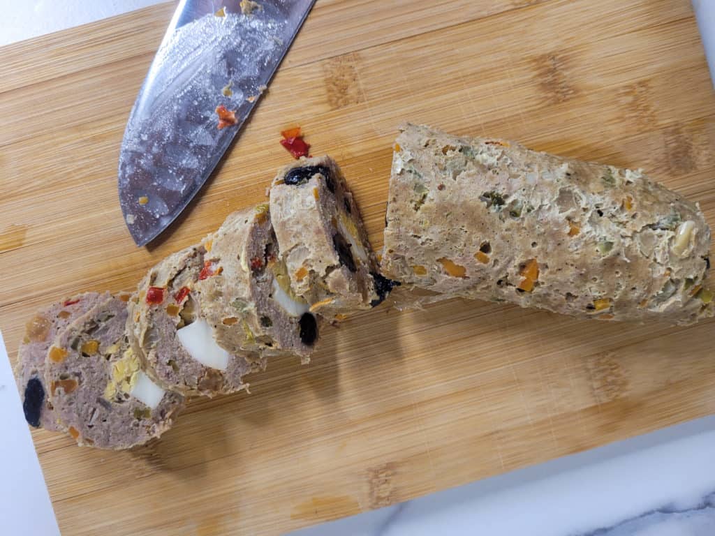 Sliced embutido or Filipino meatloaf on a chopping board