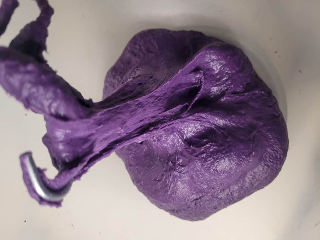 Kneaded ube cinnamon roll in a bowl