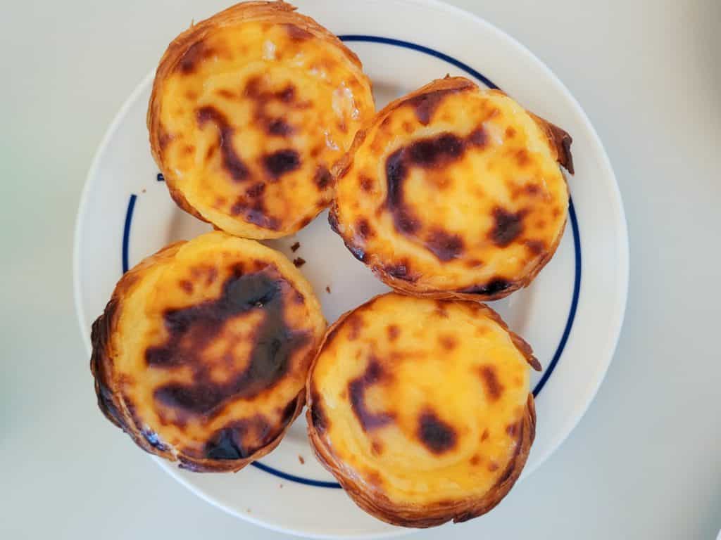 Four pieces of pasteis de Belem on a white plate