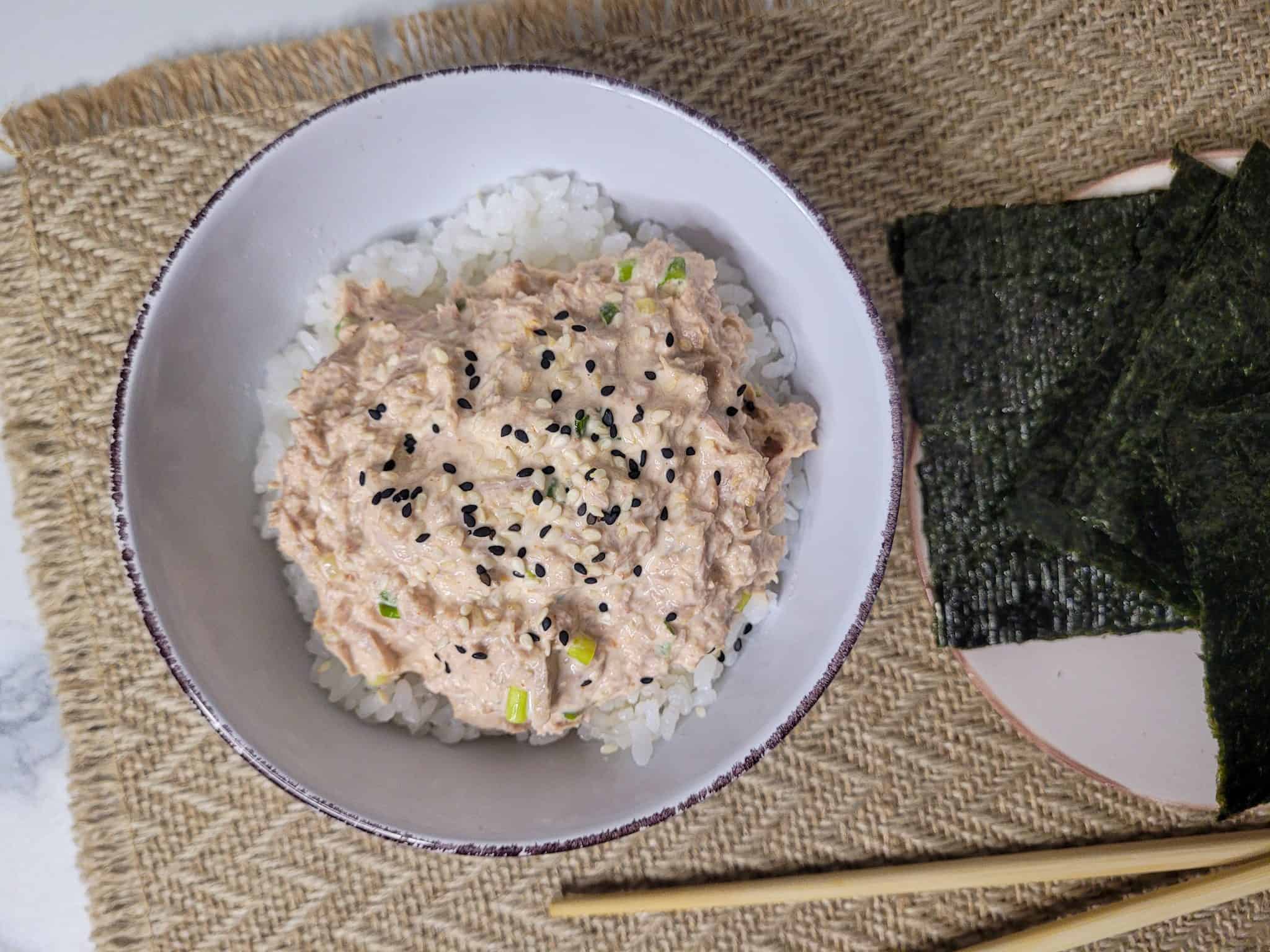 Canned spicy tuna bowl next to seaweed