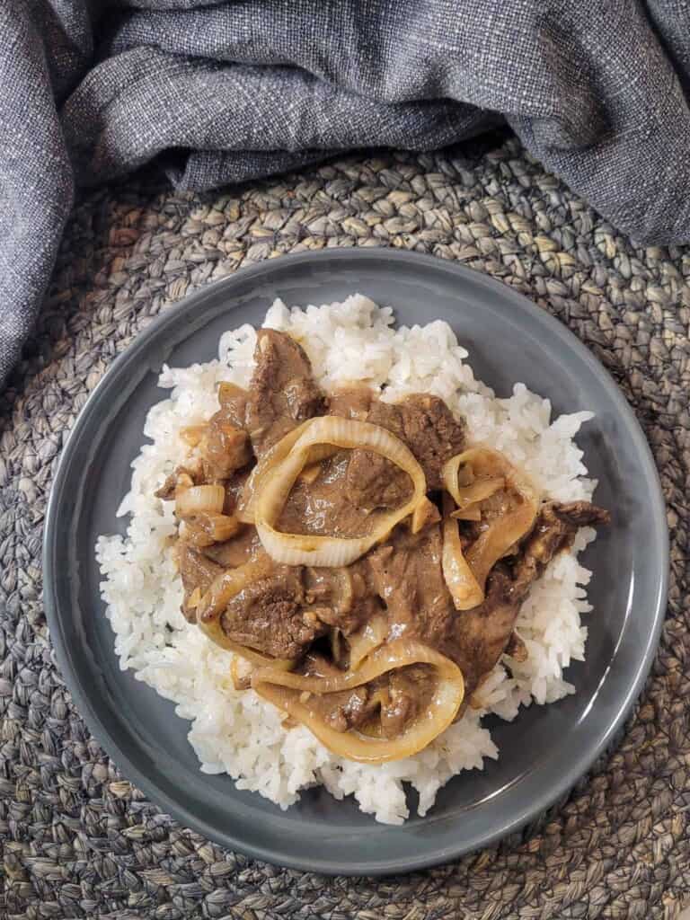 Overhead view of Bistek tagalog or Filipino beefsteak on top of rice