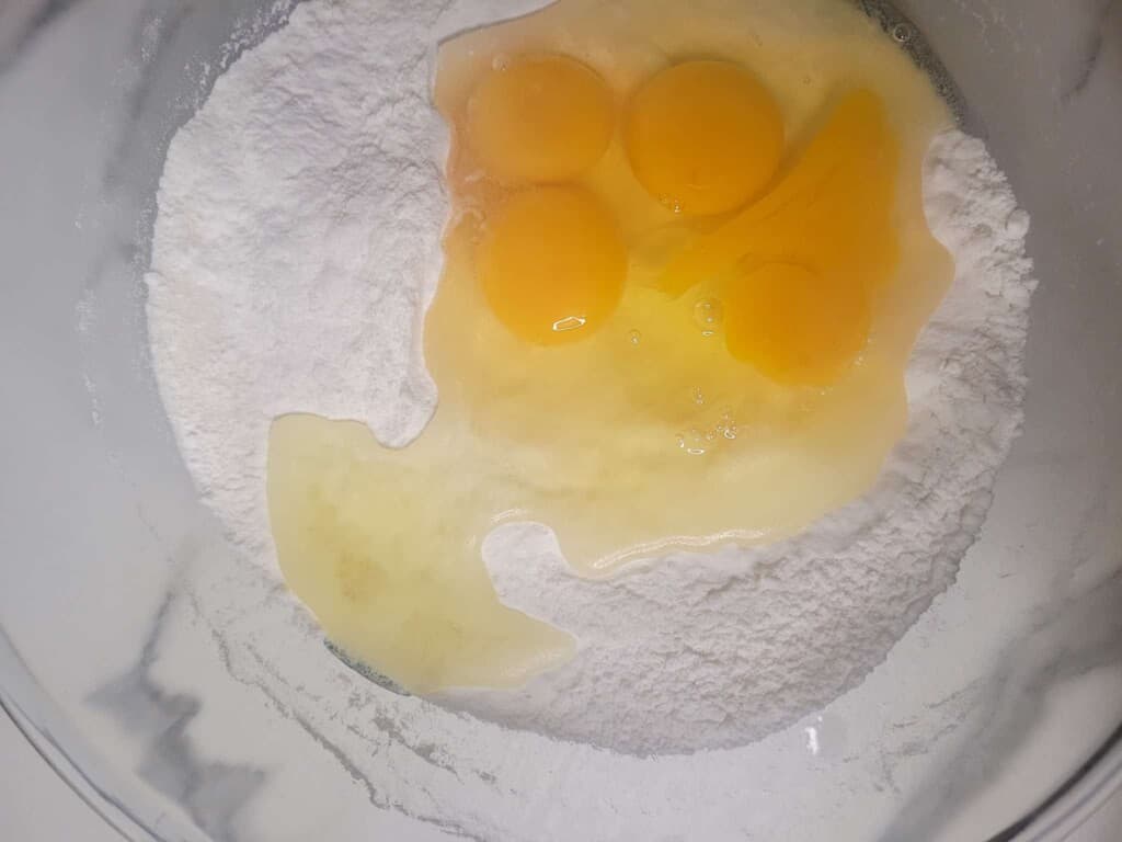 Raw eggs on top of rice flour in a bowl