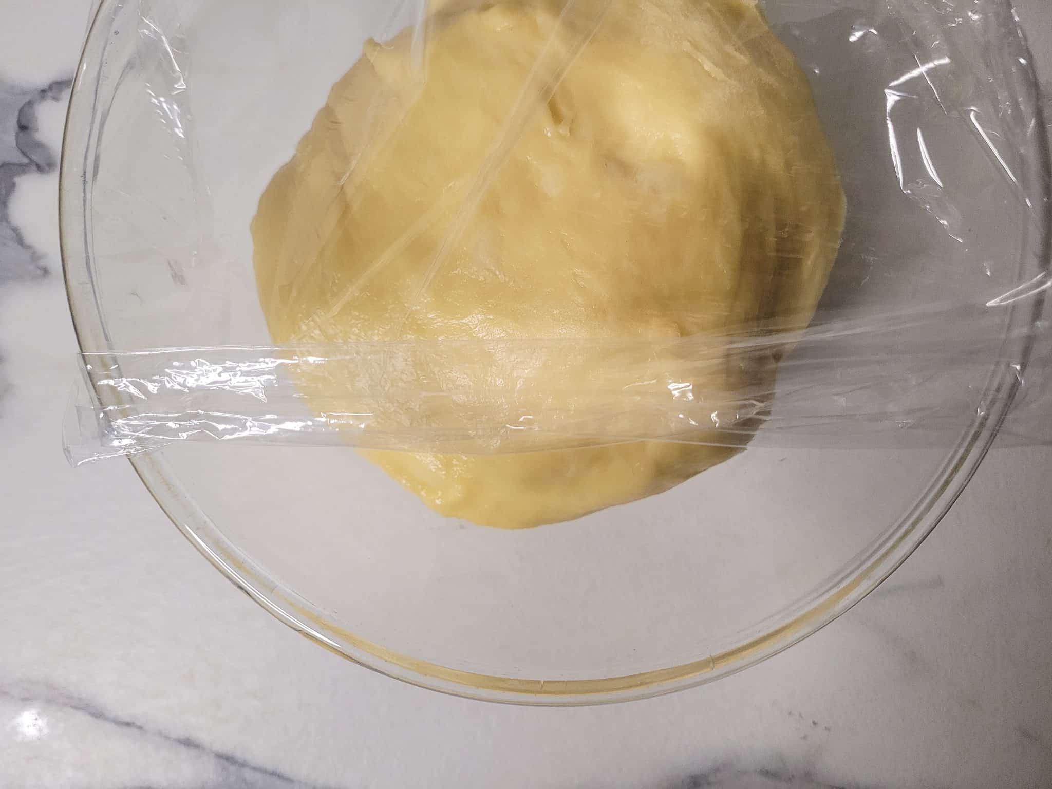 Covered dough for proofing in a glass bowl
