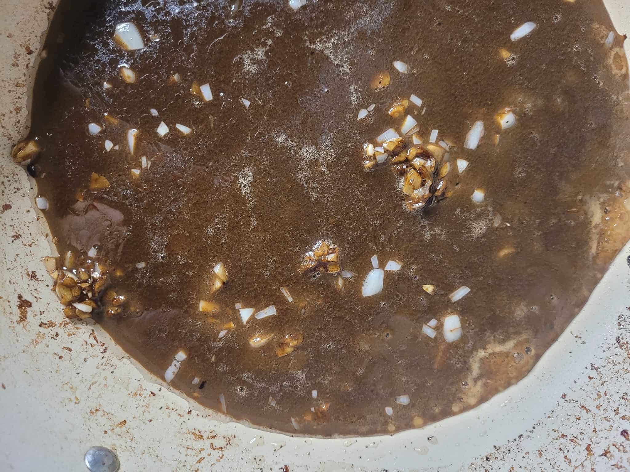 Sauteed garlic in a pan cooked with a brown sauce