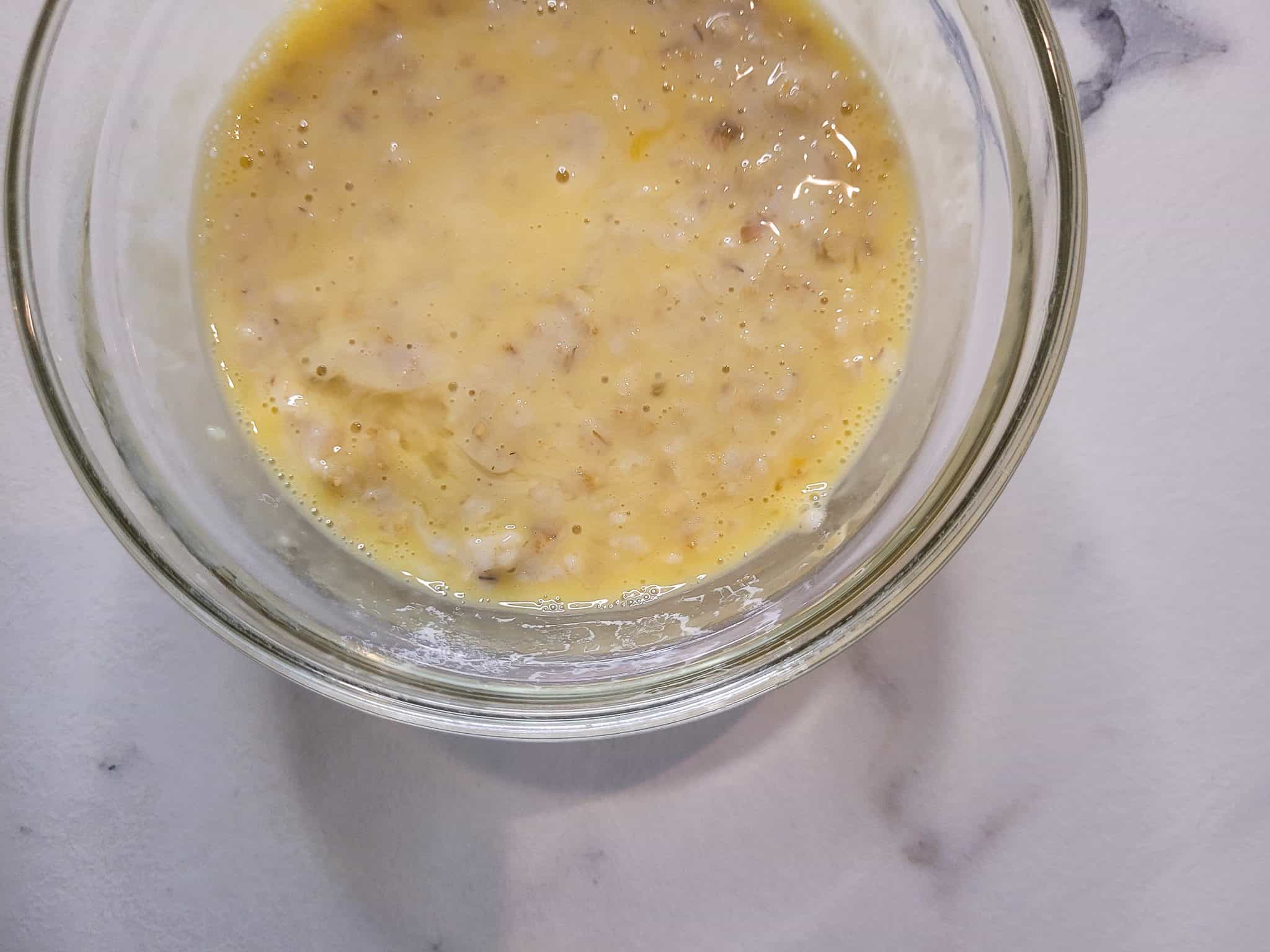 Whisked eggs and oatmeal in a bowl for custard oatmeal