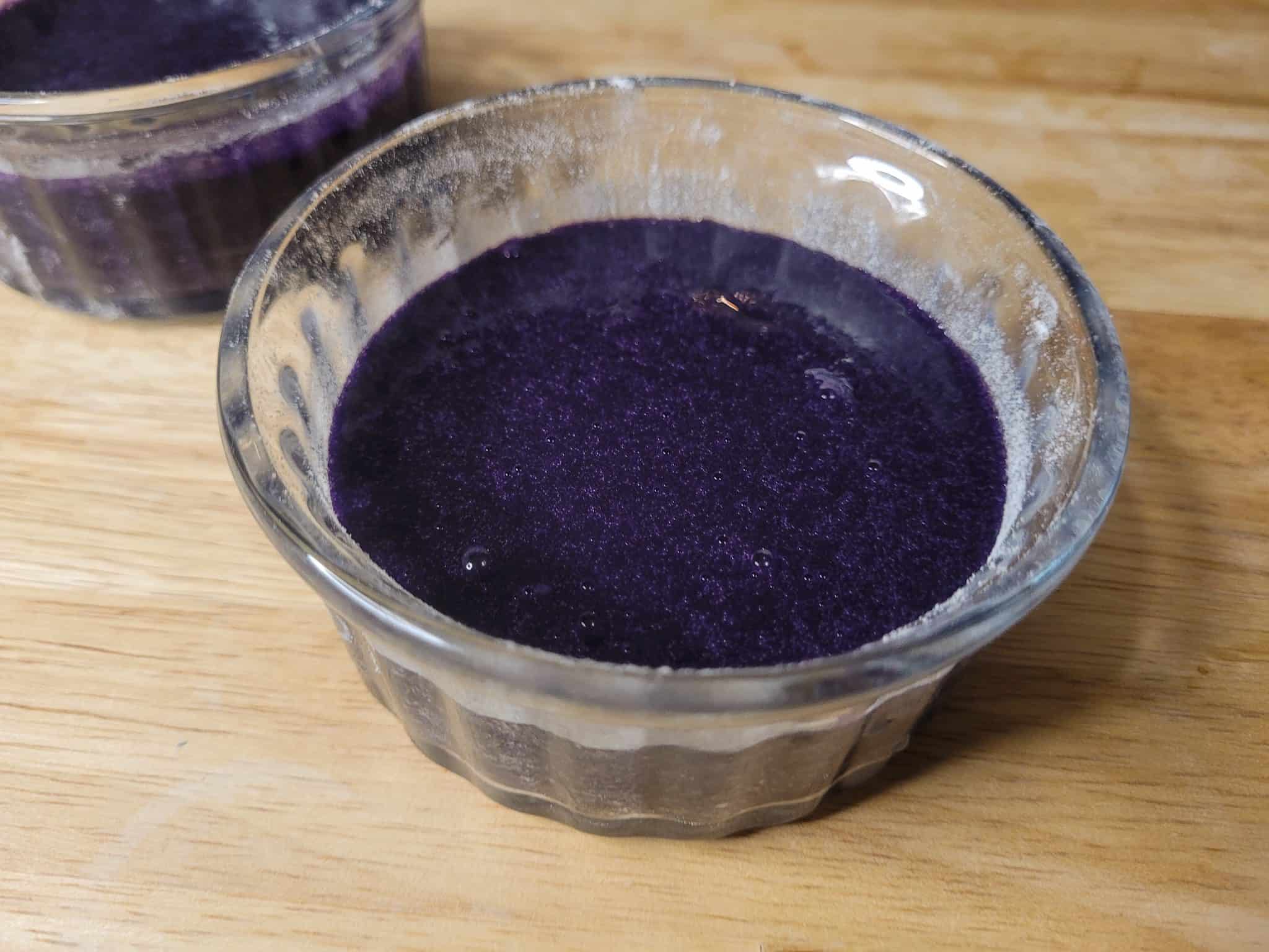 Raw ube lava cake batter in floured ramekins on a table