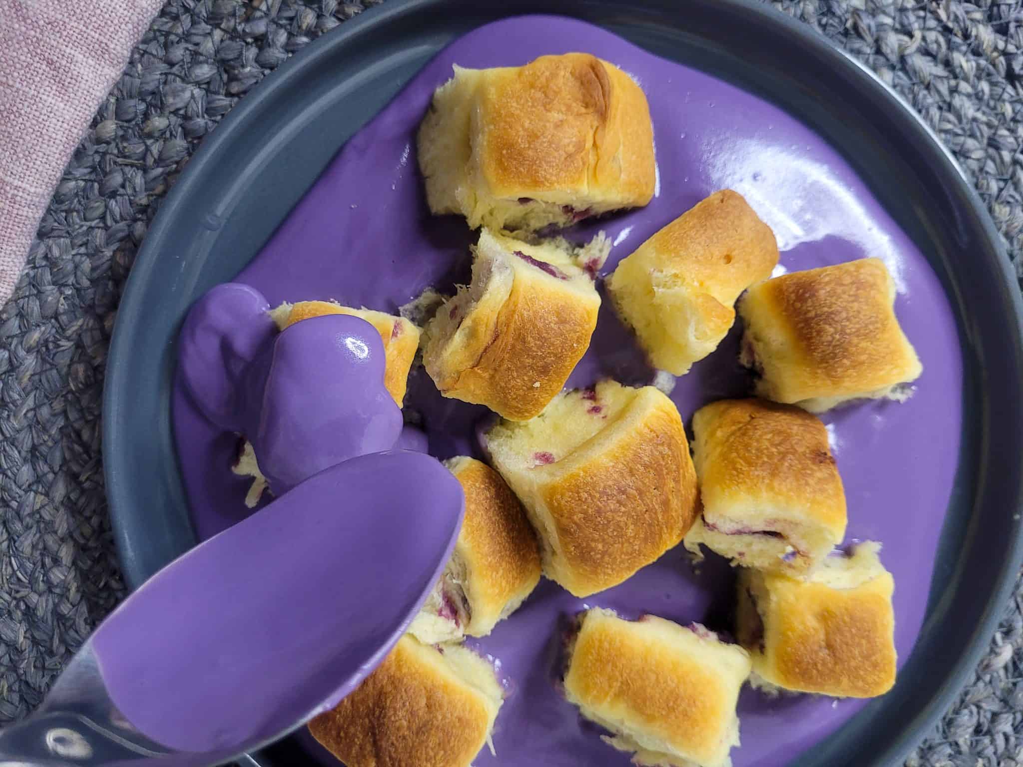 Gray plate with ube mini buns and a spoon