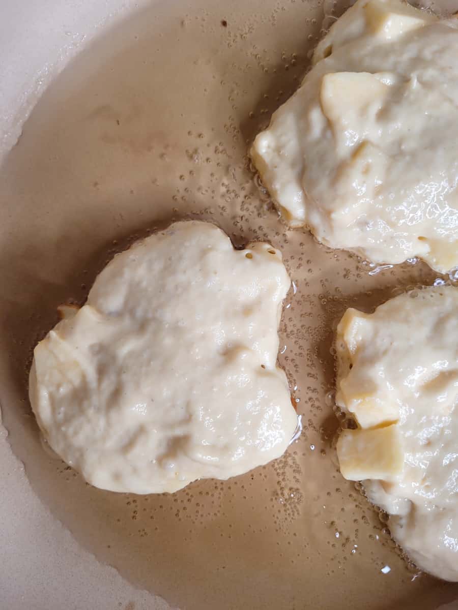 Apple fritter batter fried in pan with oil