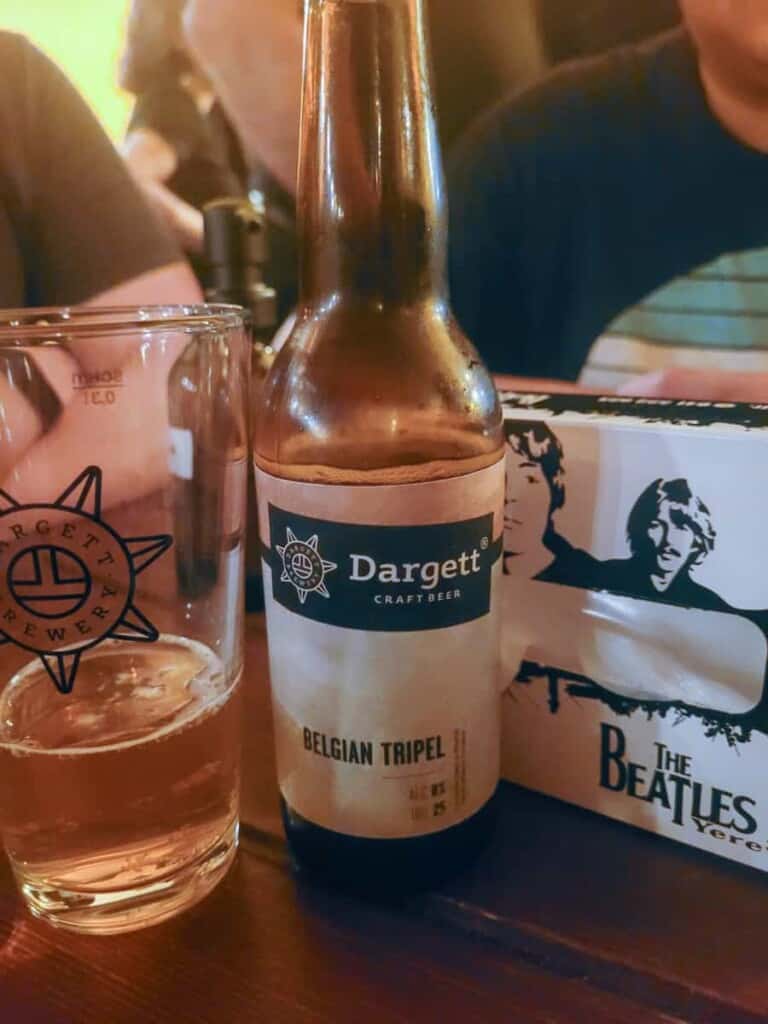 A bottle of Dargett beer next to a Beatles sign