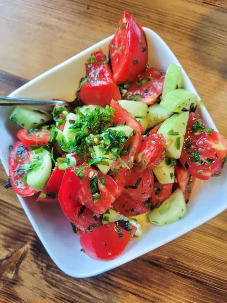 Tomato Cucumber salad on a white bowl