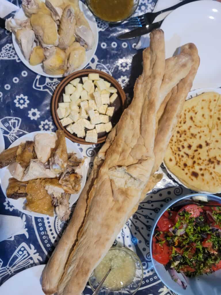 Plates of Georgian food and bread on a blue table