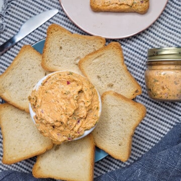 Sardine pâté on striped map next to a jar, blue towel, and a plate of bread