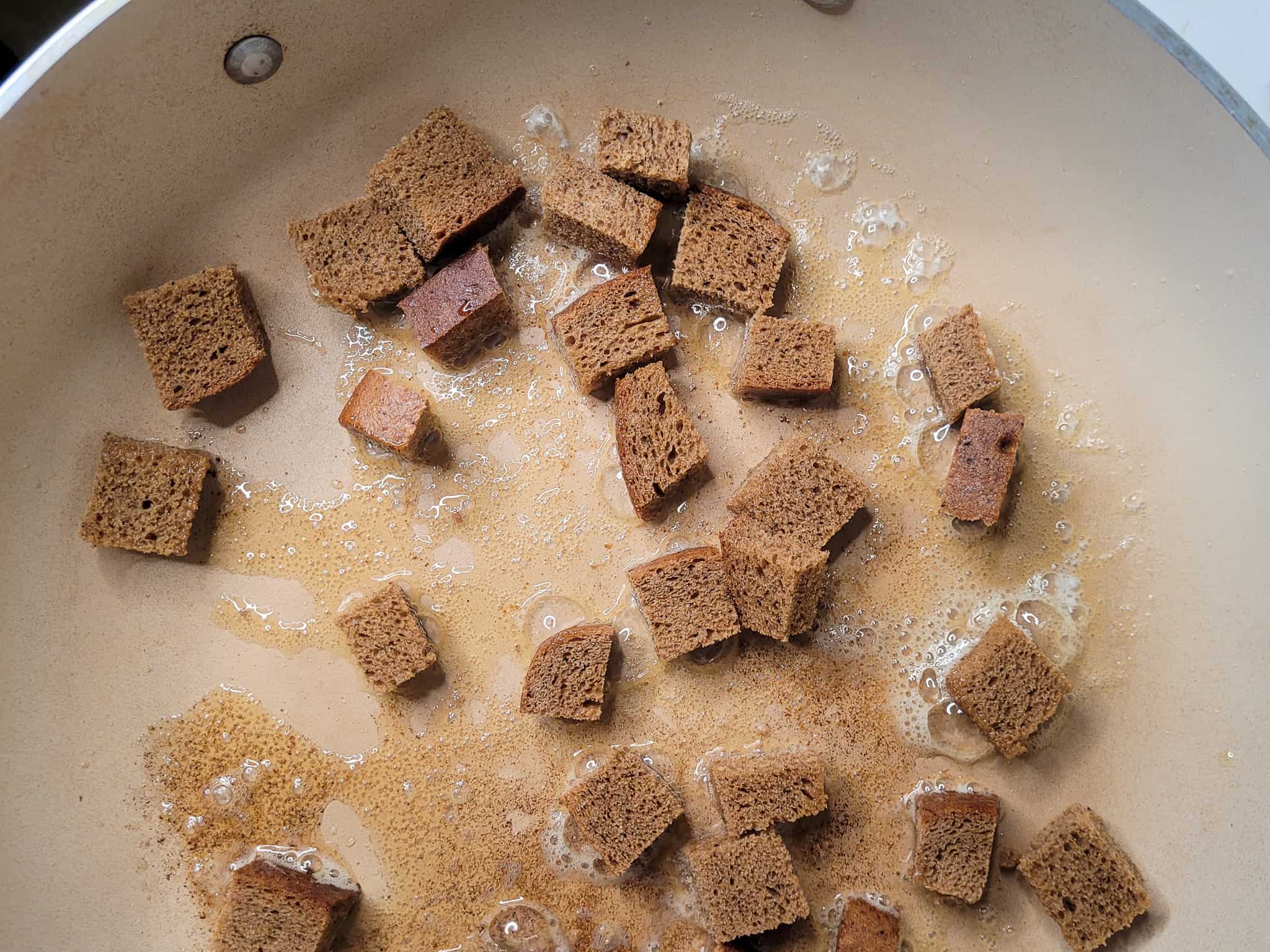 Slices of rye bread frying in a pan