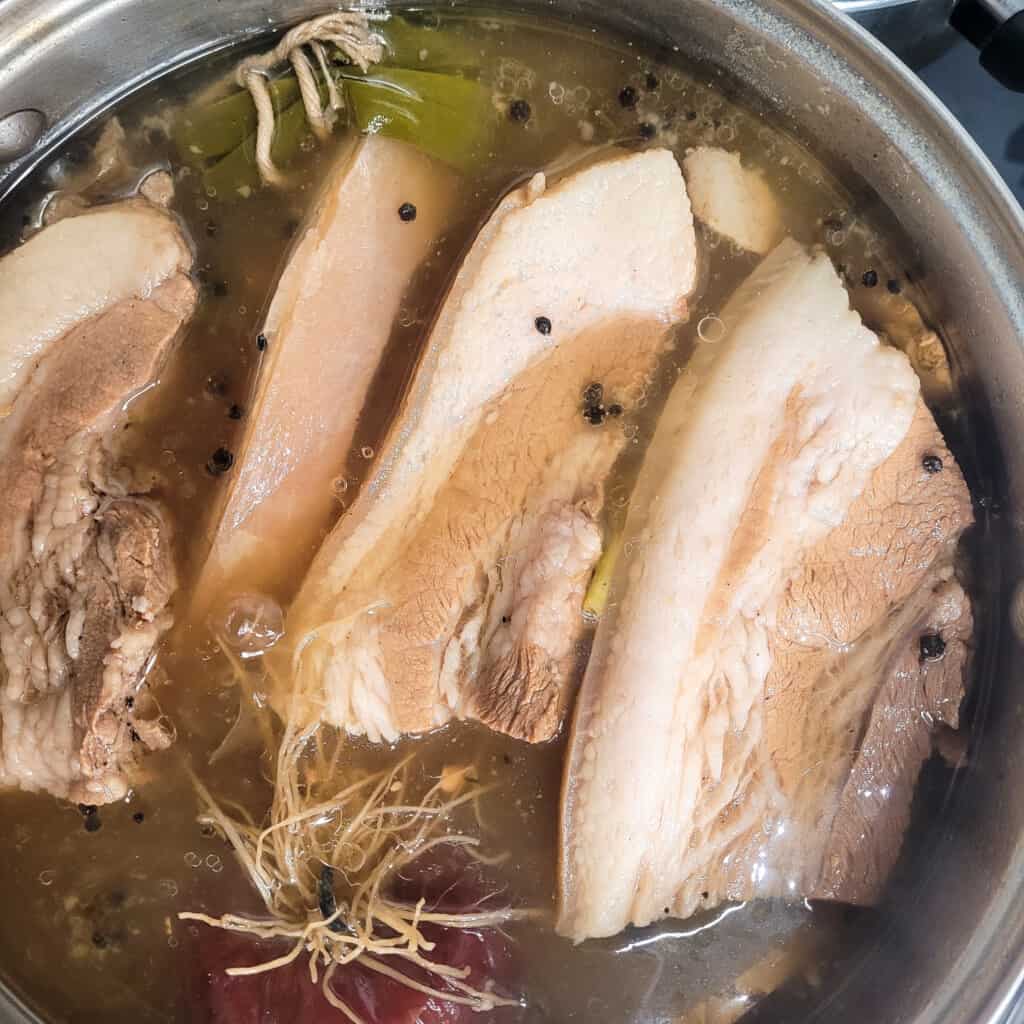 Boiled pork belly (suyuk) for bossam in a pot of seasoned water