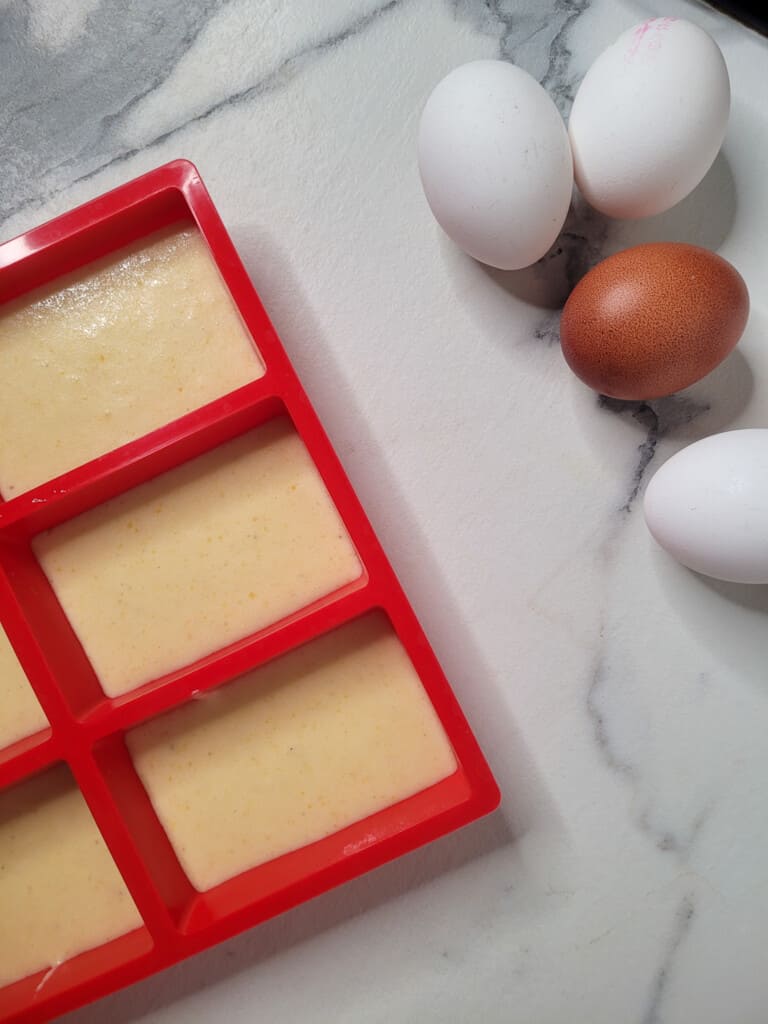 Gyeran ppang batter in red molds next to eggs