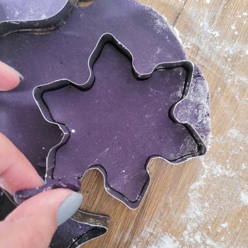 Snowflake cookie cutter with purple dough