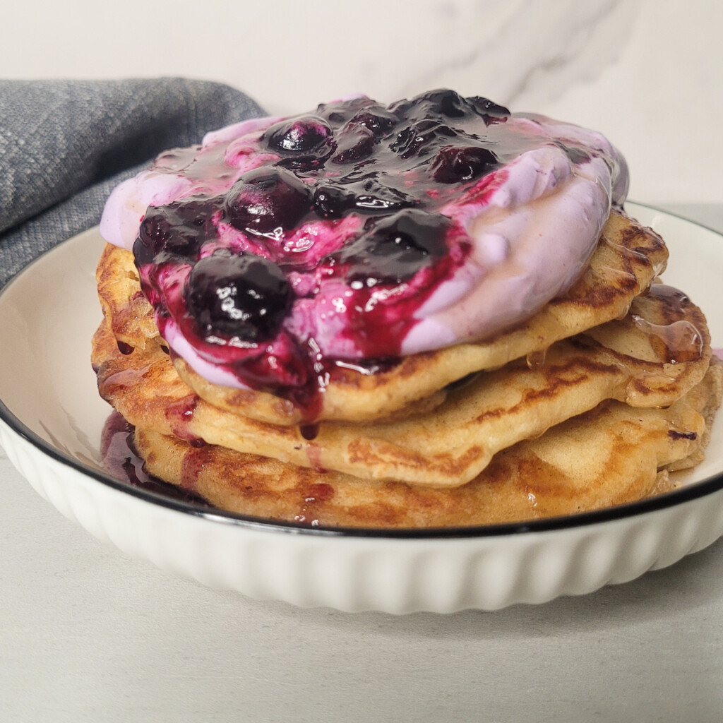 Stack of blueberry pancakes topped with blueberry sauce