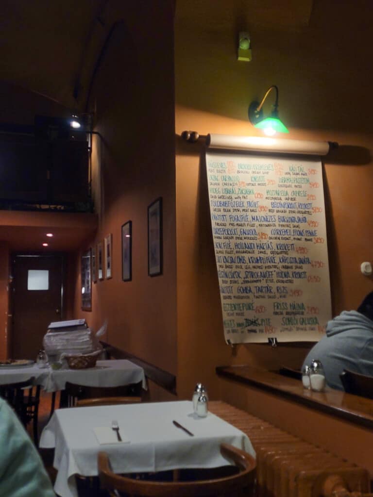 Handwritten menu of food on a restaurant wall in Budapest